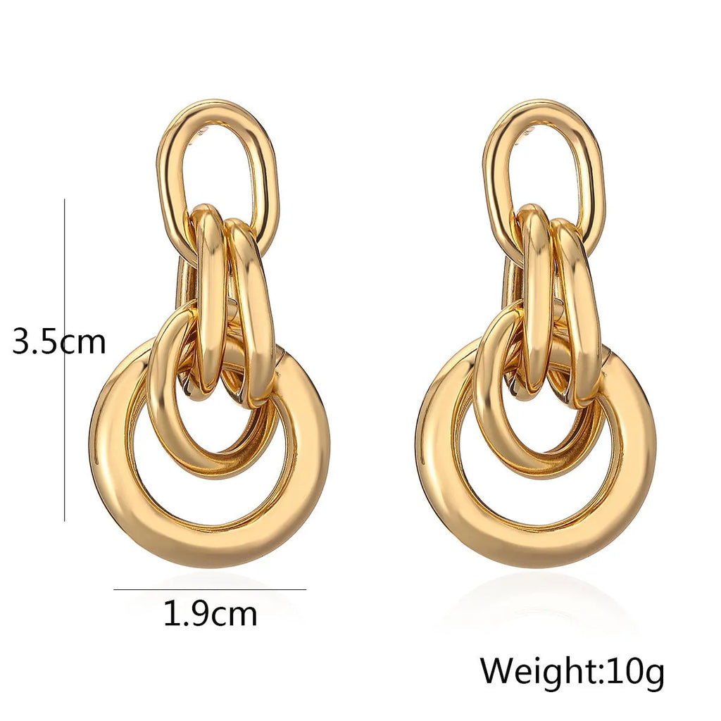A pair of real gold coloured geometric earrings with an irregular shape, made from copper, style wild.
