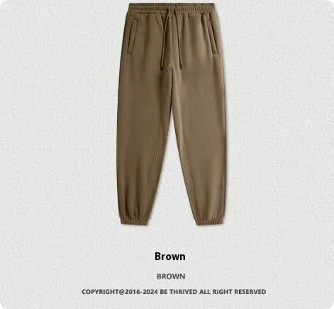Men's dark brown velvet sweatpants with elastic waistband and banded ankle cuffs on hanger