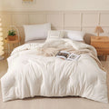 A pure cotton soybean fibre airable quilt in grey, shown with a zipper detail, on a bed.