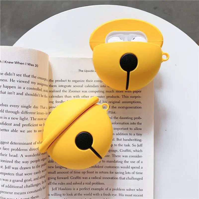 Bright yellow silicone case for AirPods 1 and 2 with a small silver bell charm attached.