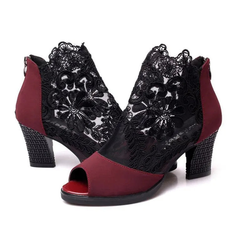 Black lace gladiator sandals with a square high heel and peep toe on a woman's foot