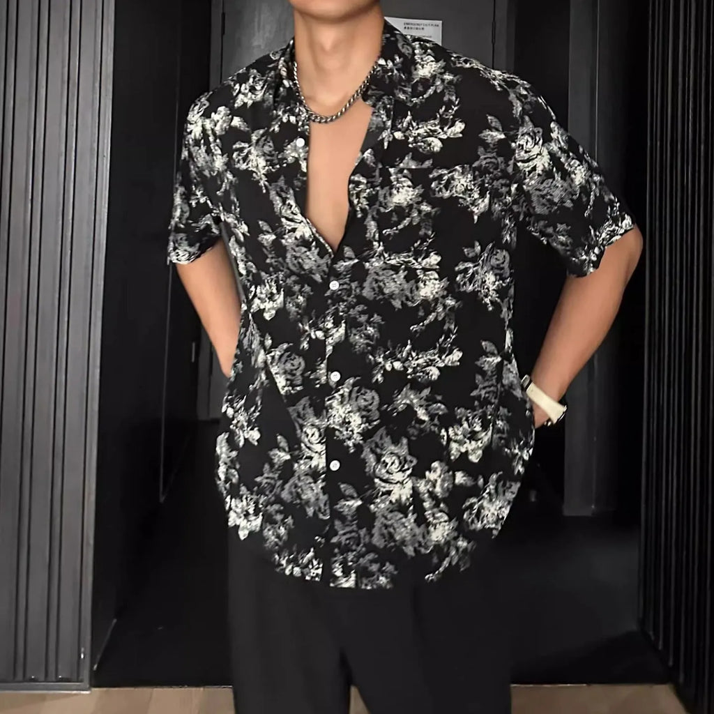 Man wearing a loose black floral print short sleeve casual shirt with a cardigan style open front.