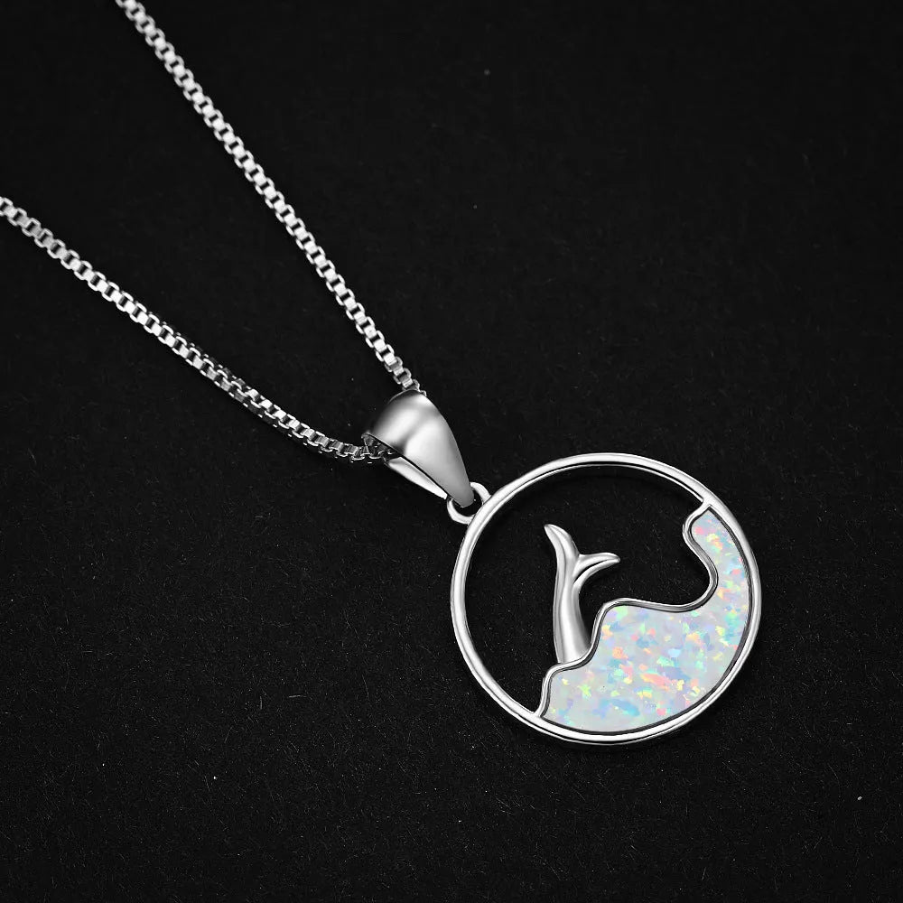 White gold electroplated necklace with a round geometric fishtail pendant in blue opal colour.