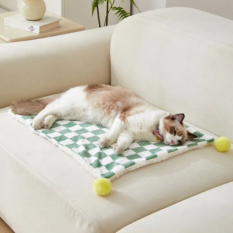 Green plaid plush pet blanket for dogs and cats on a sofa