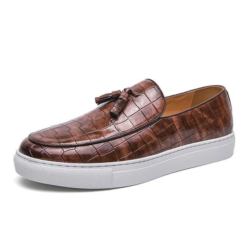 Men's black tassel detail slip-on sneakers on a white background, showing the round toe and elastic side.