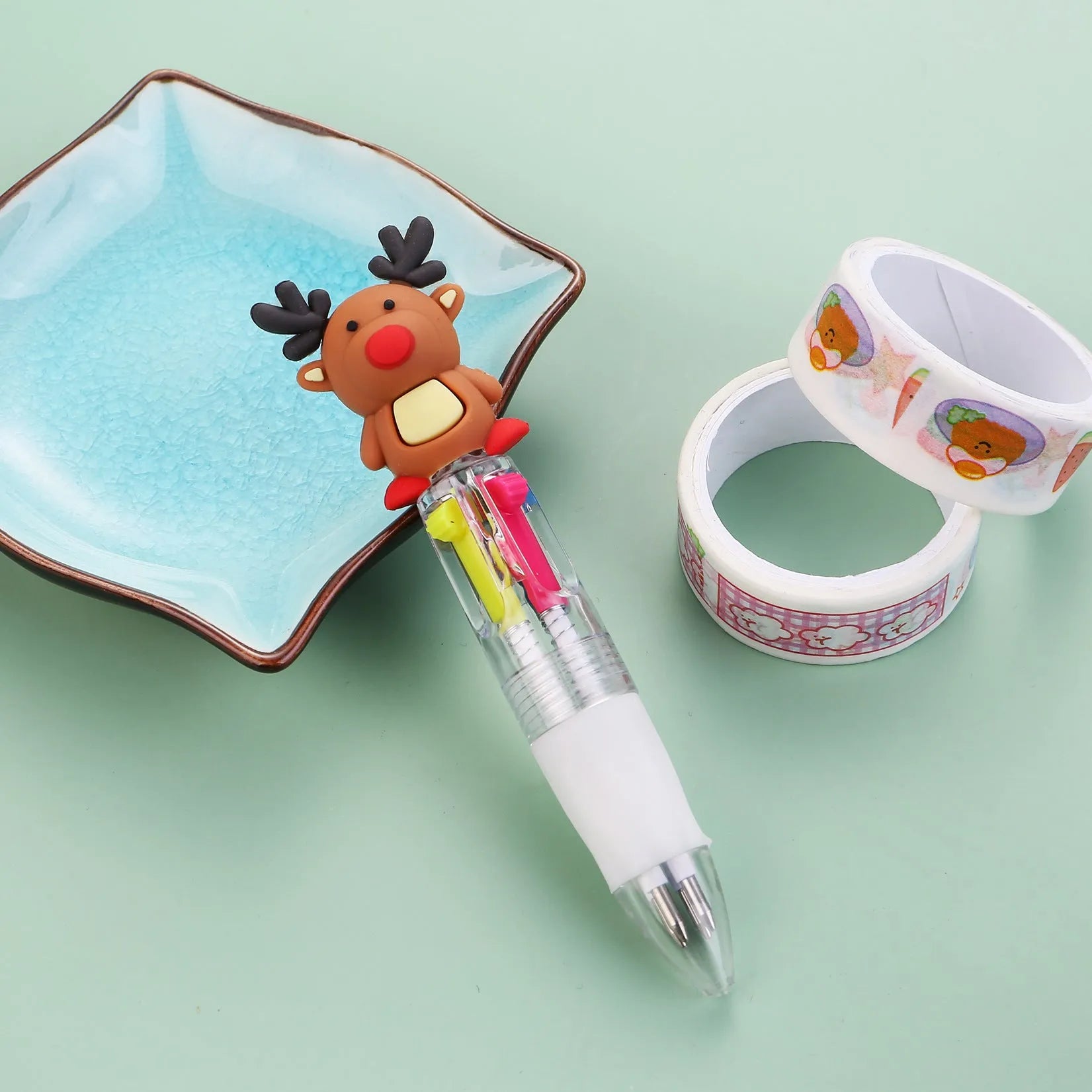 Christmas-themed ballpoint pen with press button, showing designs of snowmen, reindeer, and trees on plastic barrel.