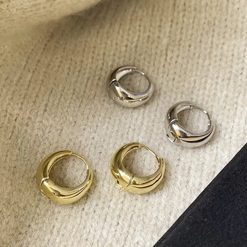 Pair of simple retro geometric alloy earrings in gold electroplated finish on a light background