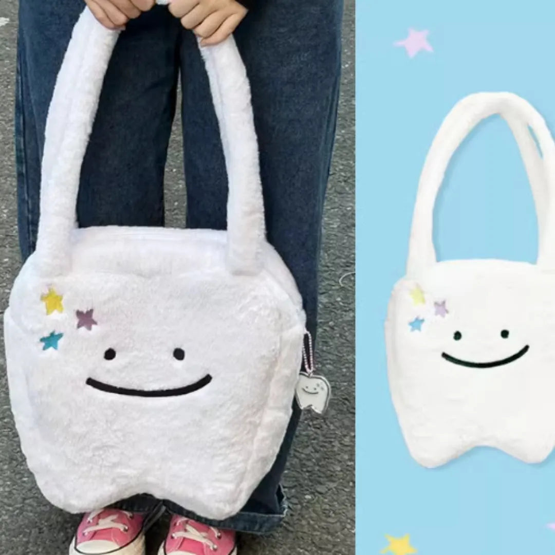 White shoulder tote bag with plush large tooth decorative detail and zip closure