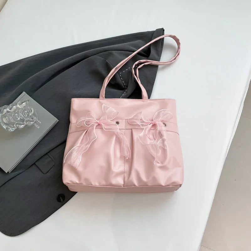 Black and pink college style bow tote bag with double straps and a front view.