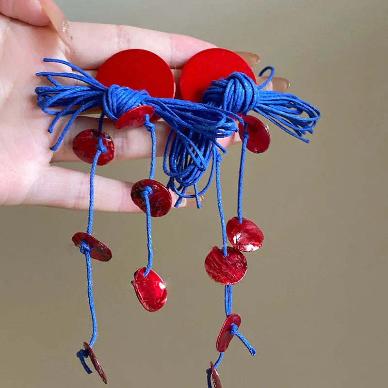 Women's geometric blue and silver fabric drop earrings with a resin flower detail.