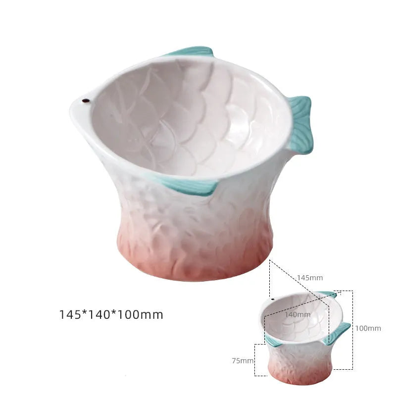 Blue ceramic fish-shaped cat bowl with tilted design and shallow eating surface on a plain background.