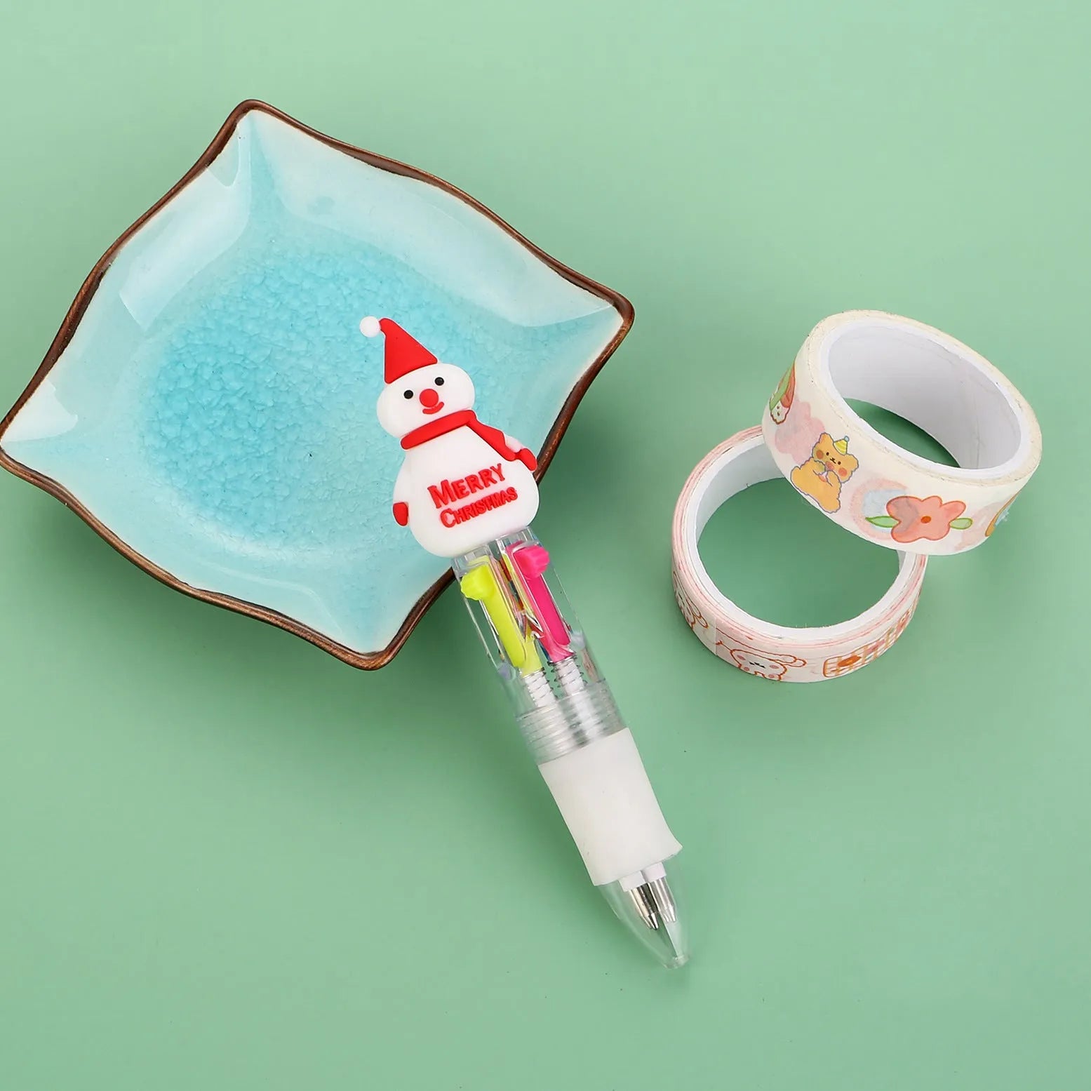 Christmas-themed ballpoint pen with press button, showing designs of snowmen, reindeer, and trees on plastic barrel.