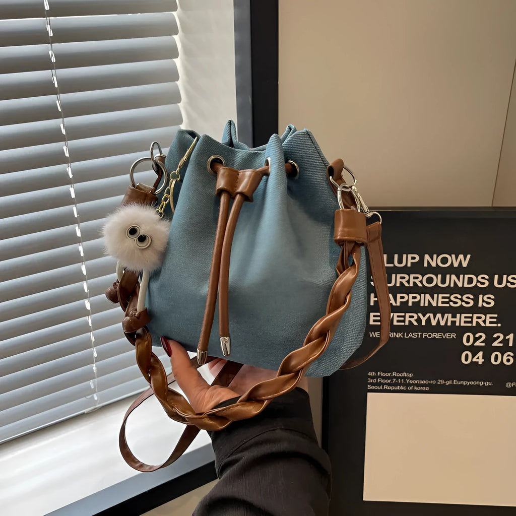 Blue one-shoulder cross body bucket messenger bag with an external sandwich pocket.