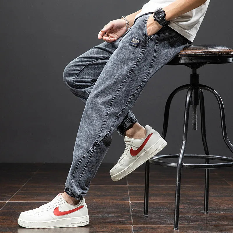 Man wearing loose fit straight leg cargo jeans in blue, showing zipper fly and cargo pocket detail.