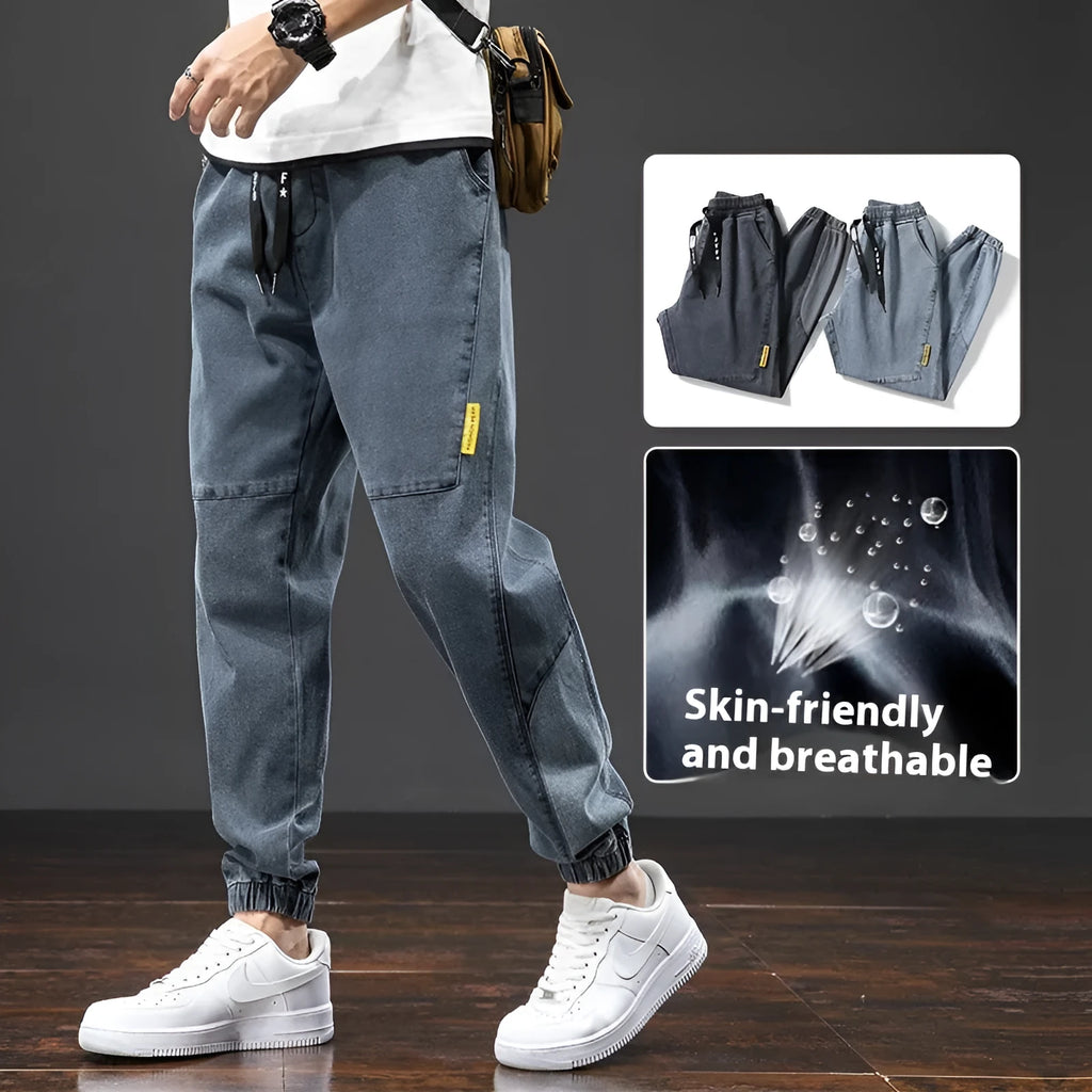 Man wearing loose fit straight leg cargo jeans in blue, showing zipper fly and cargo pocket detail.