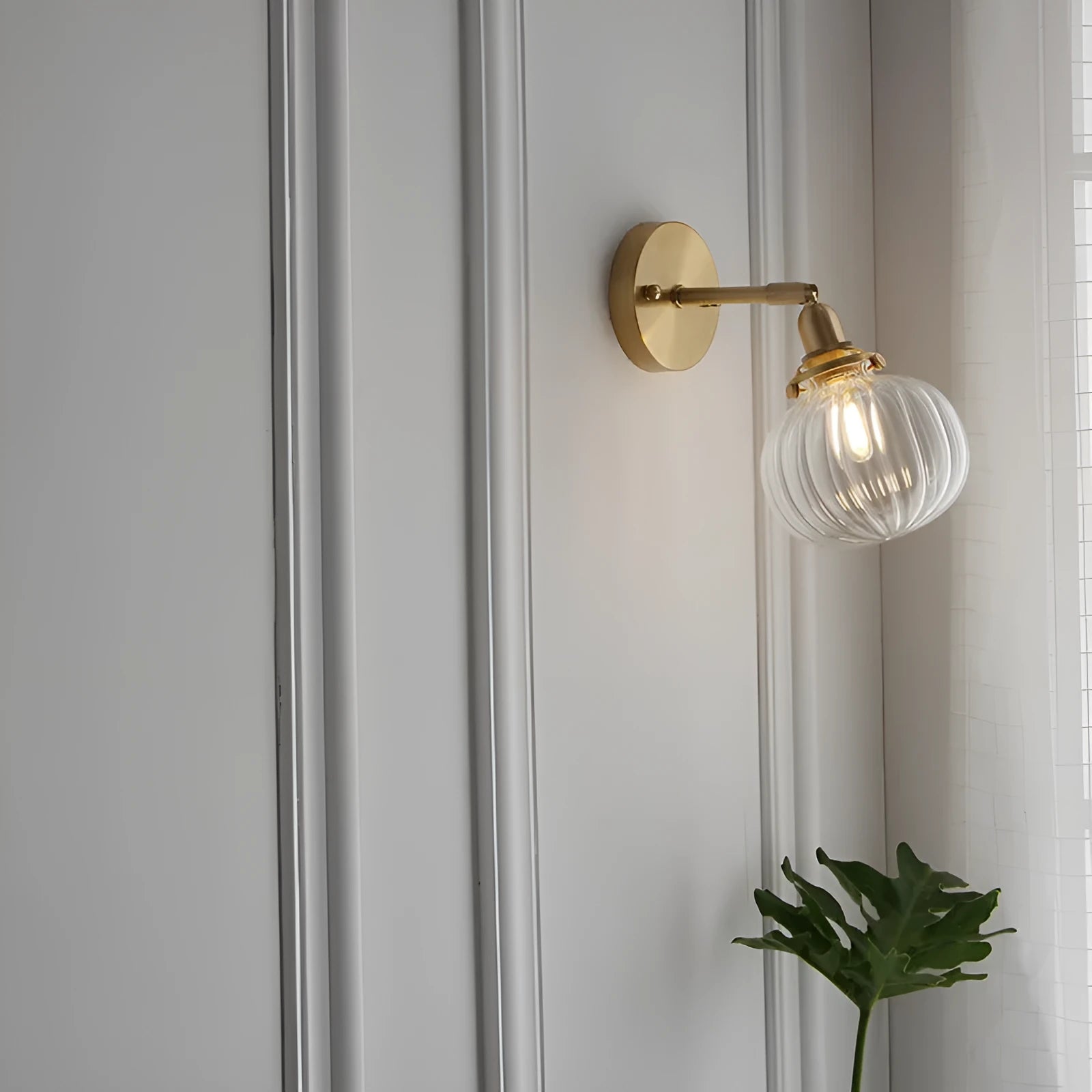 Pumpkin-shaped transparent glass wall lamp mounted on a wall