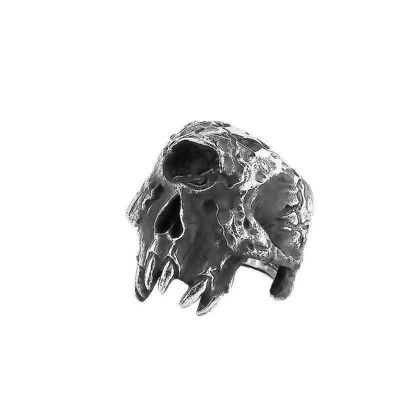 Close-up of a silver-toned alloy ring with a detailed one-eyed skull design on the finger.