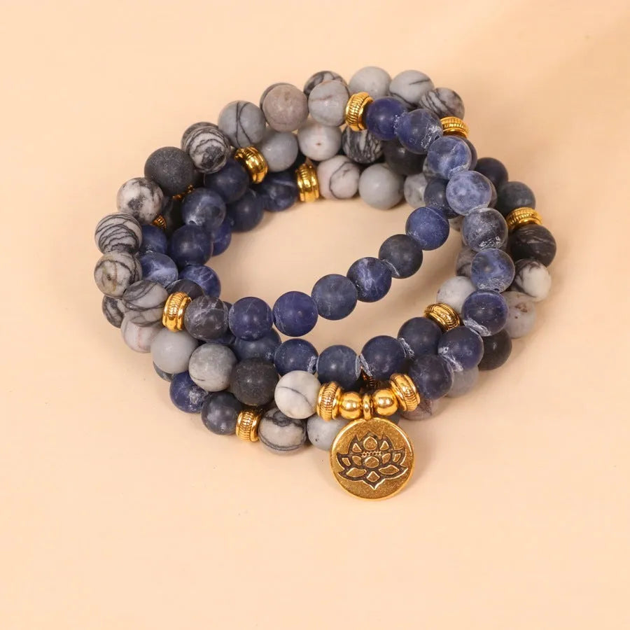 Close-up of a blue patterned network stone bead multi layer alloy bracelet on a wrist