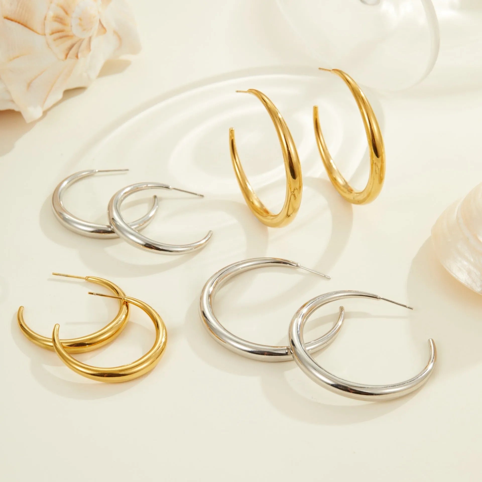 Geometric round stainless steel hoop earrings with gold plating, shown in large and small sizes.