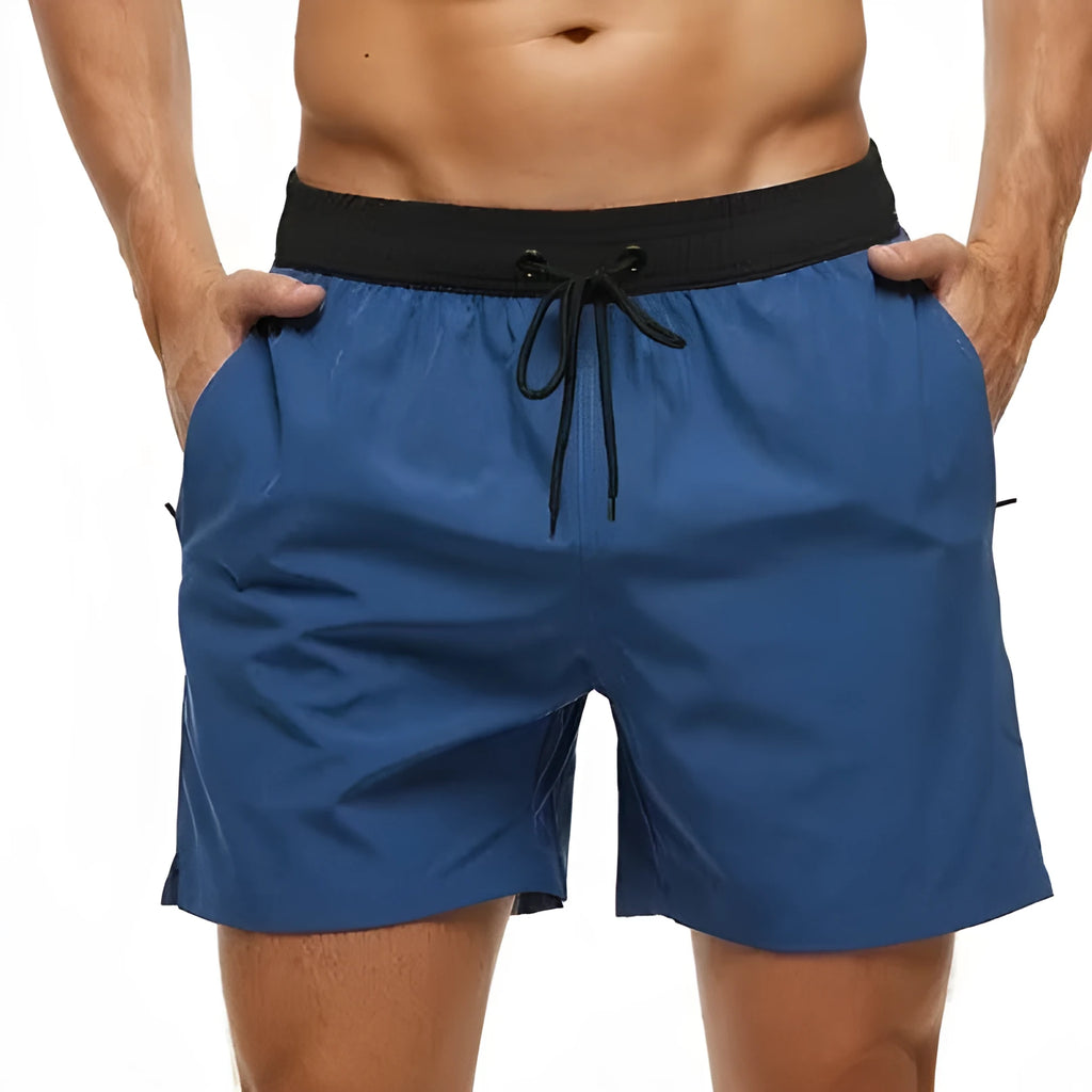 Men's blue drawstring athletic shorts with a zipper pocket and stitching detail on the waistband
