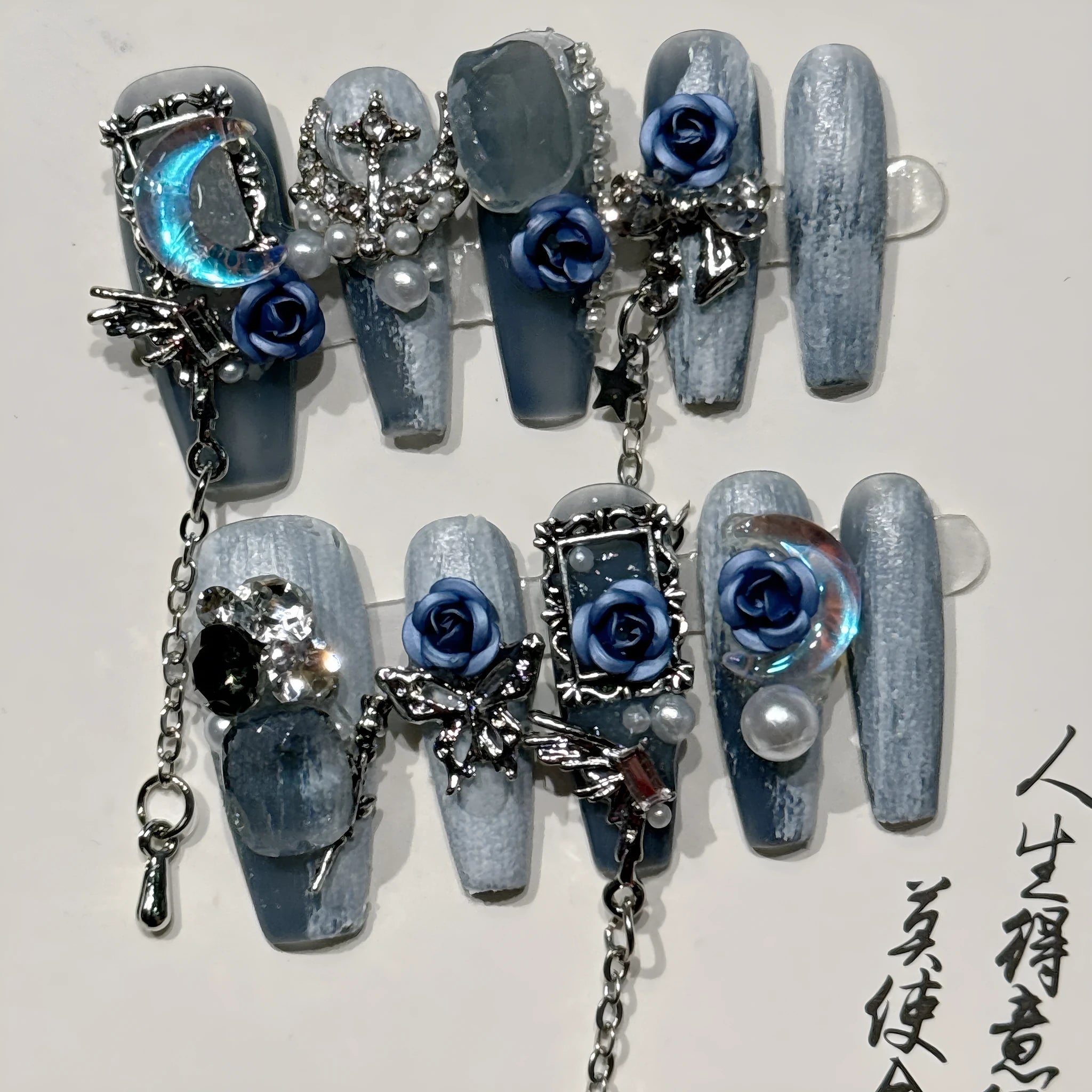 Women's ornate rose floral pattern manicure nails in heavy industry blue colour on a plastic armour suit.