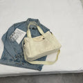 Large polyester canvas shoulder tote bag in solid colour with outer pocket and shoulder strap