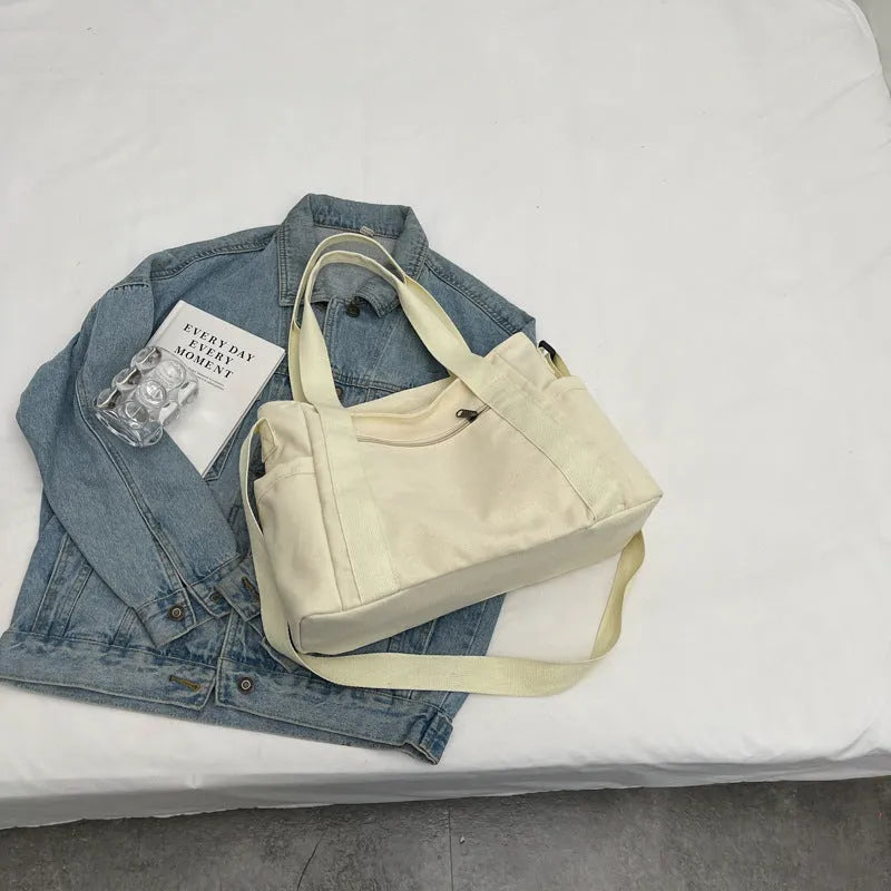 Large polyester canvas shoulder tote bag in solid colour with outer pocket and shoulder strap