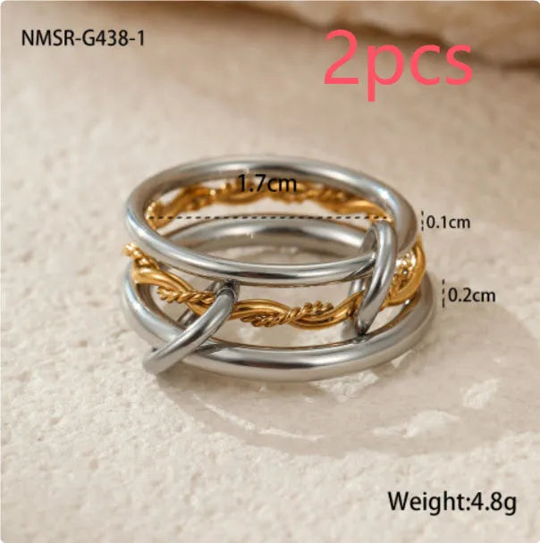 Stacked gold plated stainless steel ring set showing exaggerated design on a model's hand.