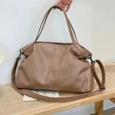 Large soft PU leather messenger bag in khaki colour with adjustable shoulder strap and top handle.