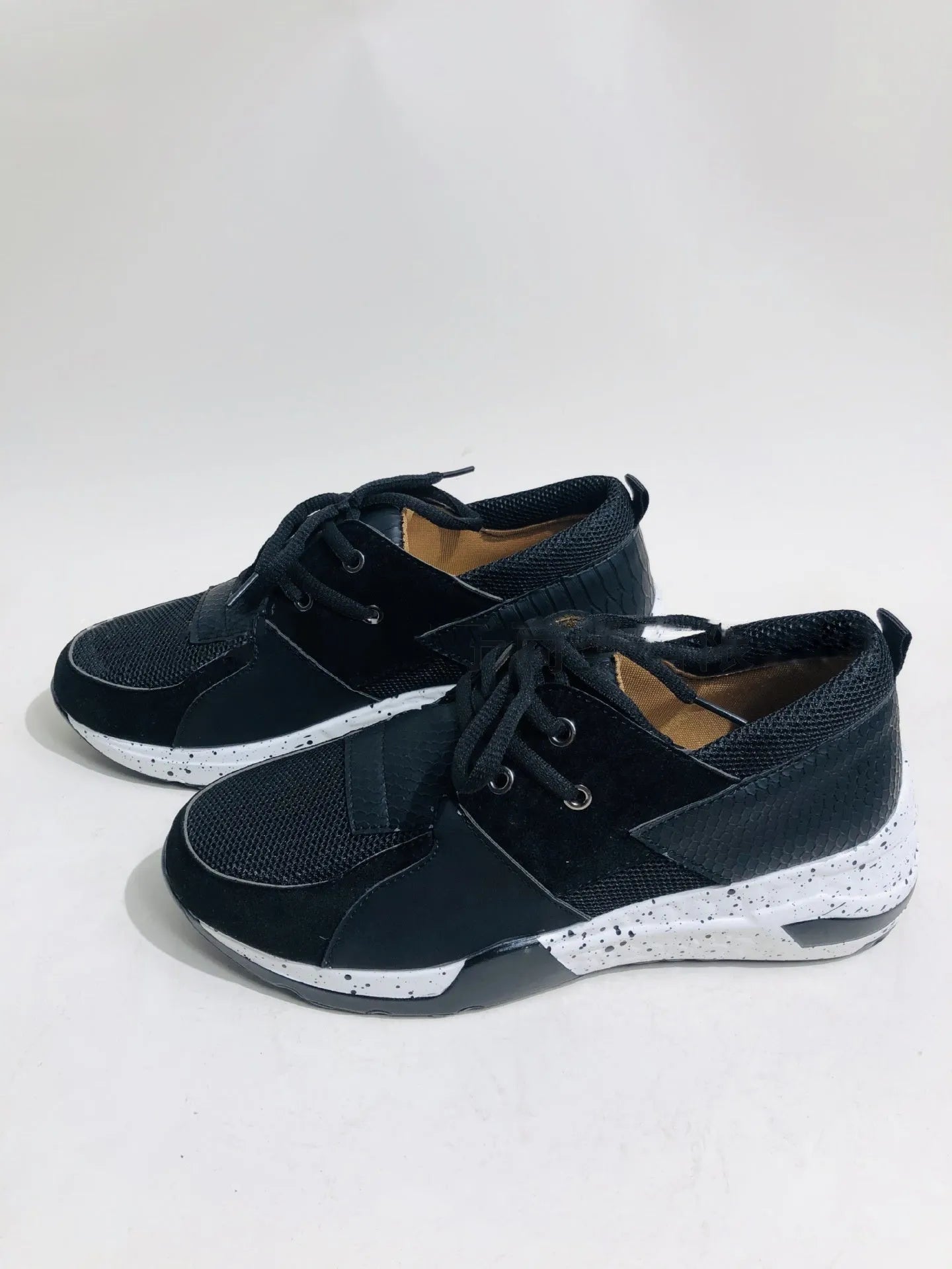 Women's black suede casual sneakers with a wedge heel and round toe on a light background.