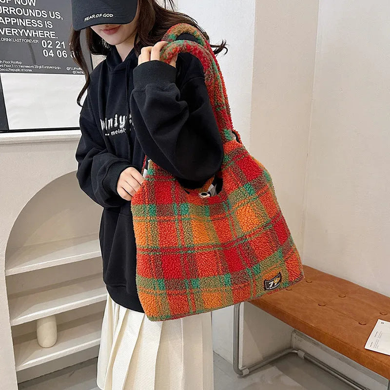 Women's plaid pattern crossbody tote bag showing soft plush material and horizontal square shape with crossbody strap.