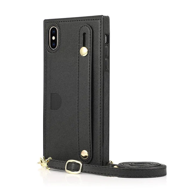 Black leather iPhone case with card holder slot and detachable wrist strap on a table