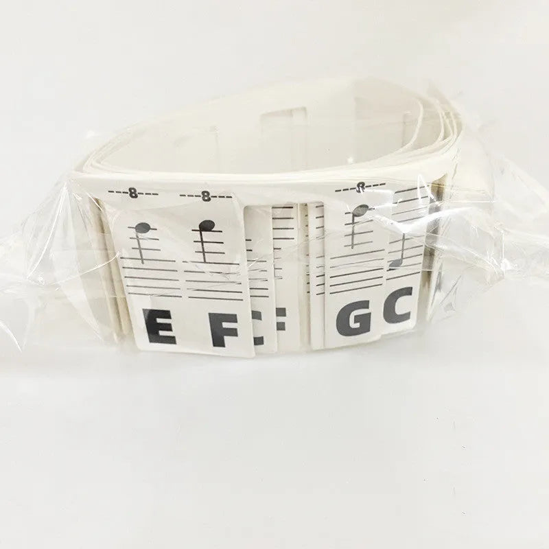 Two bags of white card piano keyboard stickers for 88 keys, showing colour note bar and black note designs.