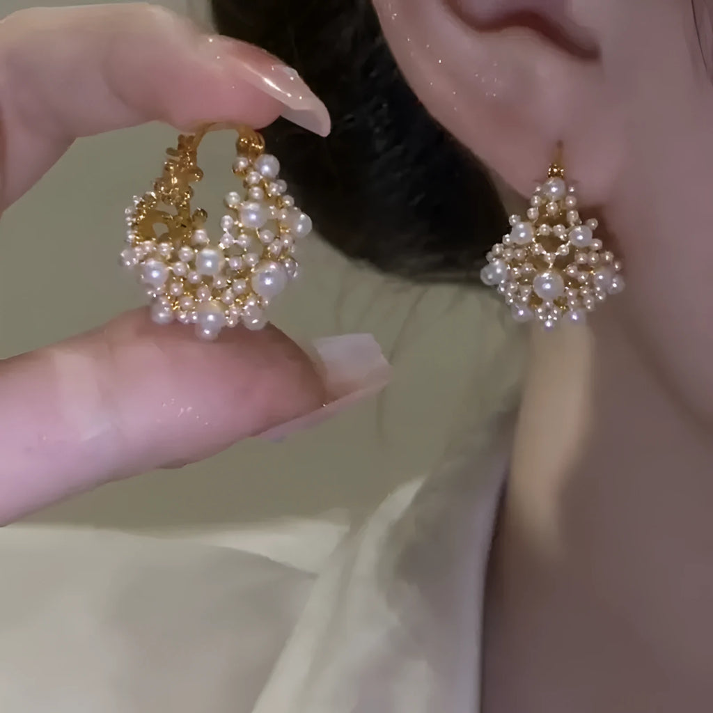 Gold-coloured copper flower basket earrings with small rice-shaped bead inlay detail.