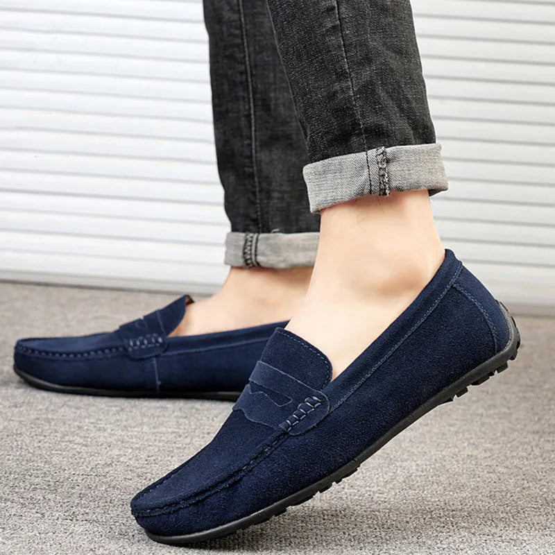 Men's solid colour suede leather slip-on loafers with a flat rubber sole.