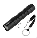 Black aluminium alloy mini LED flashlight showing compact size next to a AA battery for scale.