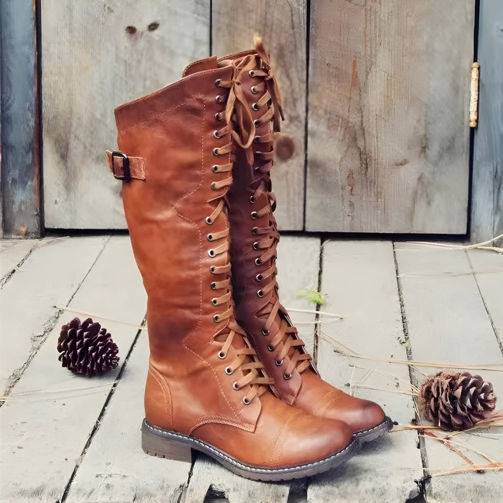 Women's black chunky heel high-leg boots with a round toe and low block heel on a plain background.