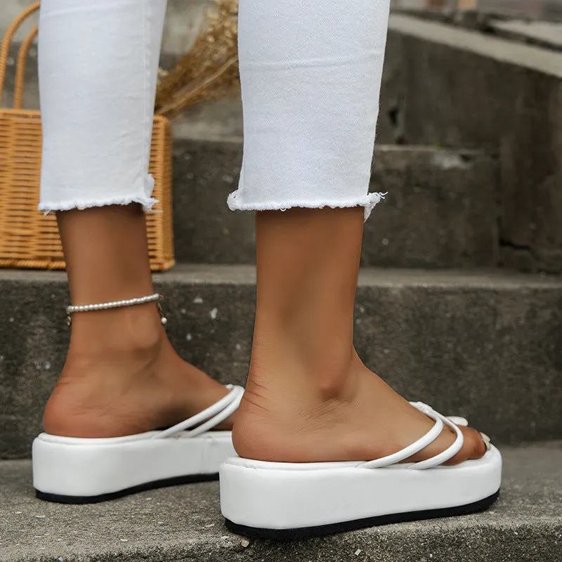 A pair of thick-soled herringbone pattern flip-flops in one of six colours on a plain background.