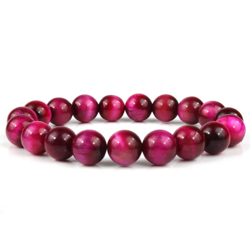 Tiger eye crystal stone bracelet showing round beads available in multiple colours and sizes on a wrist.