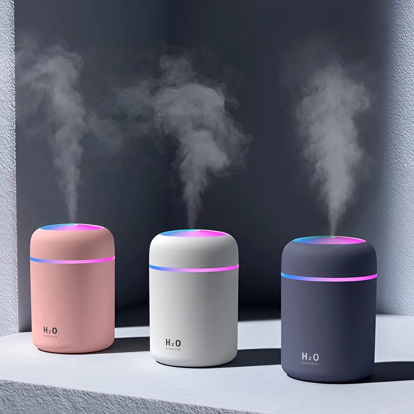 Pink USB mini humidifier with LED lights and water tank on desk