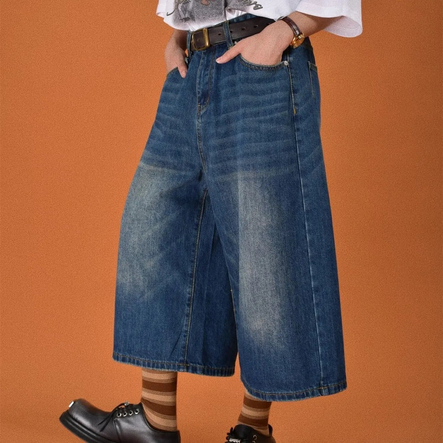Men's loose fit jeans shorts in blue denim with a straight leg, shown on a model.