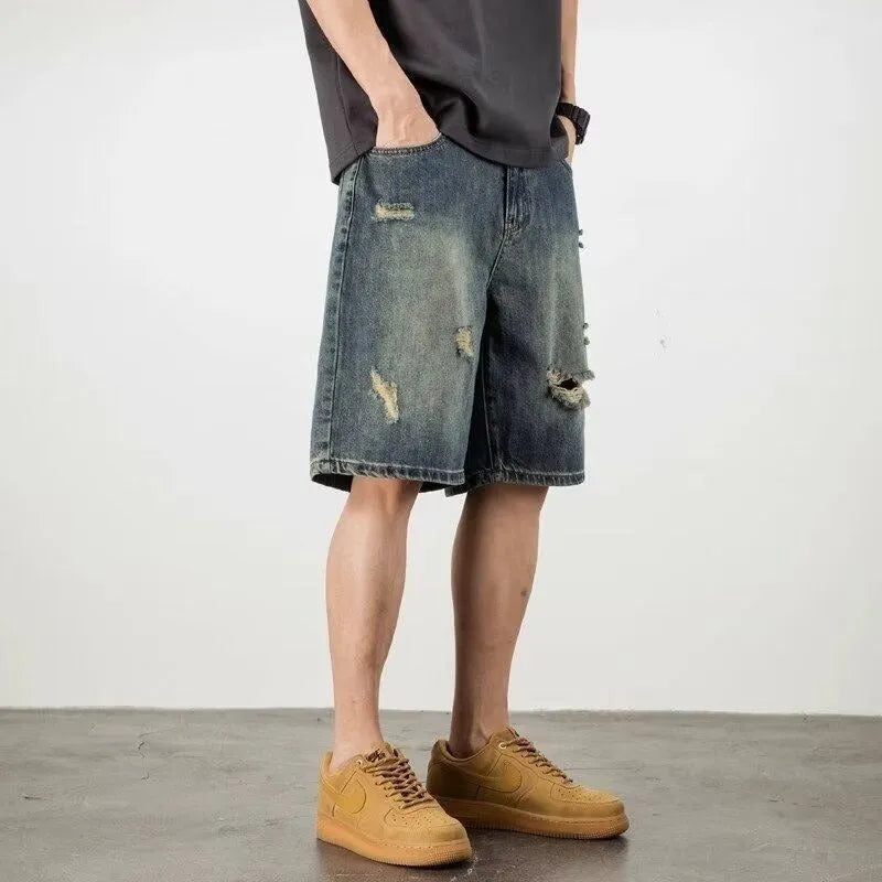 Man wearing blue retro distressed denim shorts with a straight leg cut.