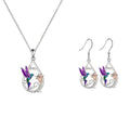White electroplated copper hummingbird necklace and earring set with animal motifs on a neutral background