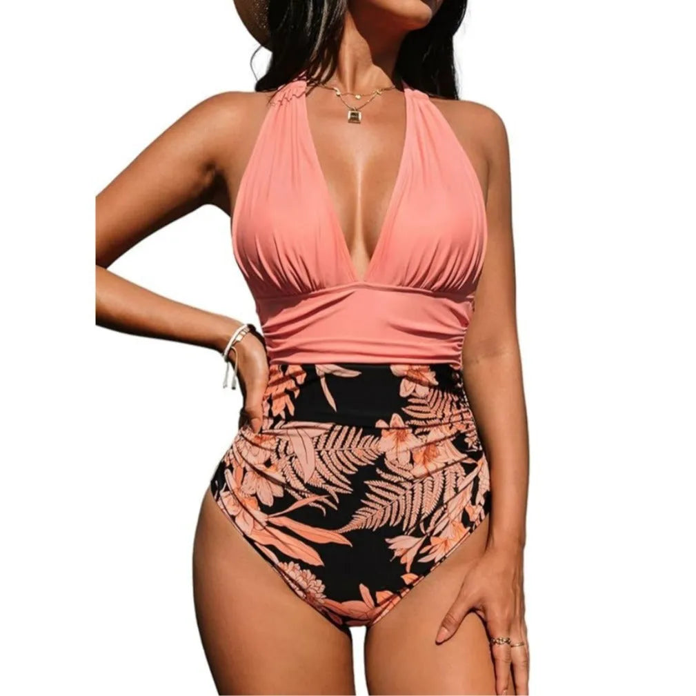 Women's pink floral one-piece halter neck swimsuit on a mannequin, showing backless design.
