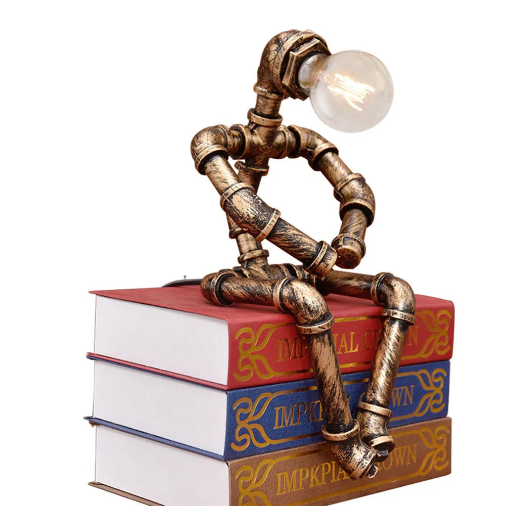 Green bronze vintage robot table lamp with industrial iron pipe design on wooden desk