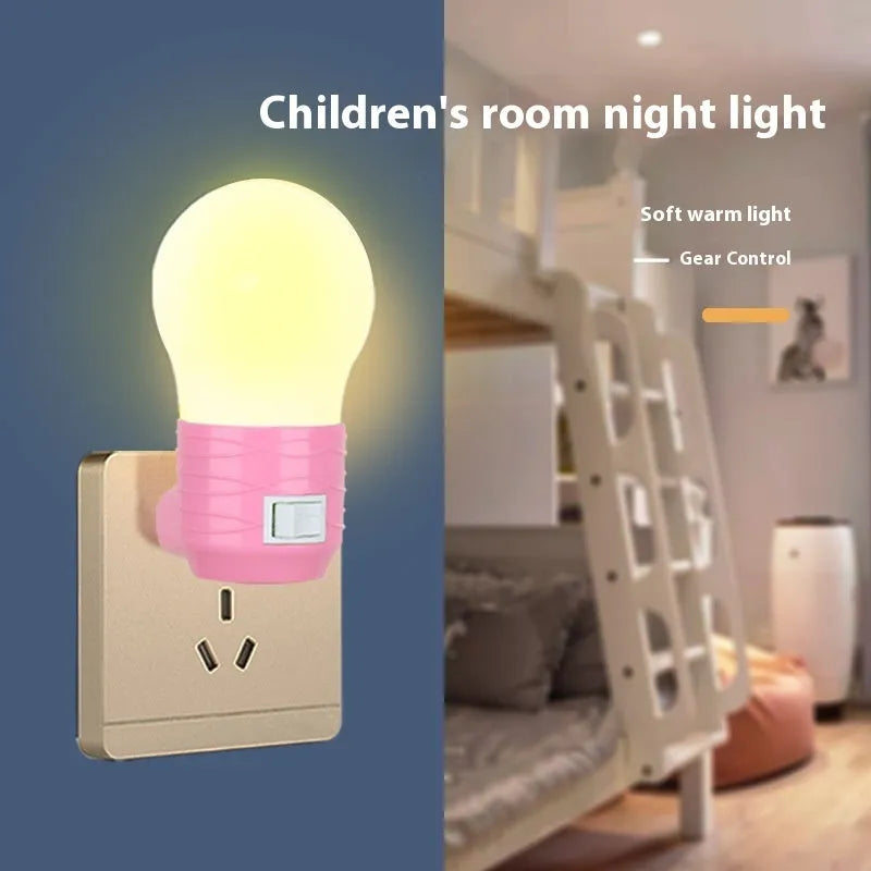 Plug-in bedside baby night light in white, blue, or pink shell with round design on a table
