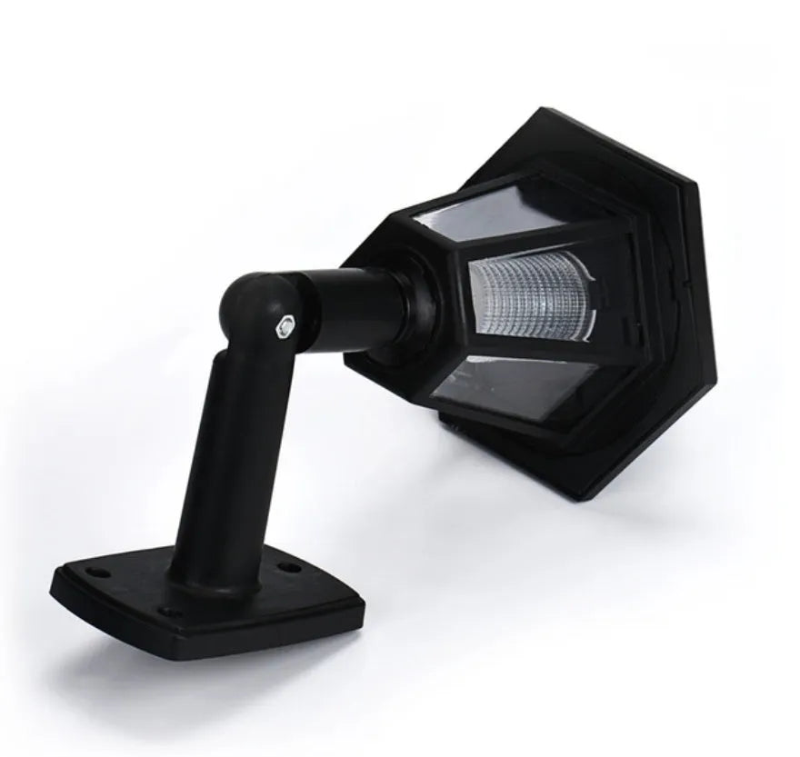 Black hexagonal solar wall lamp with light sensor mounted on an outdoor wall