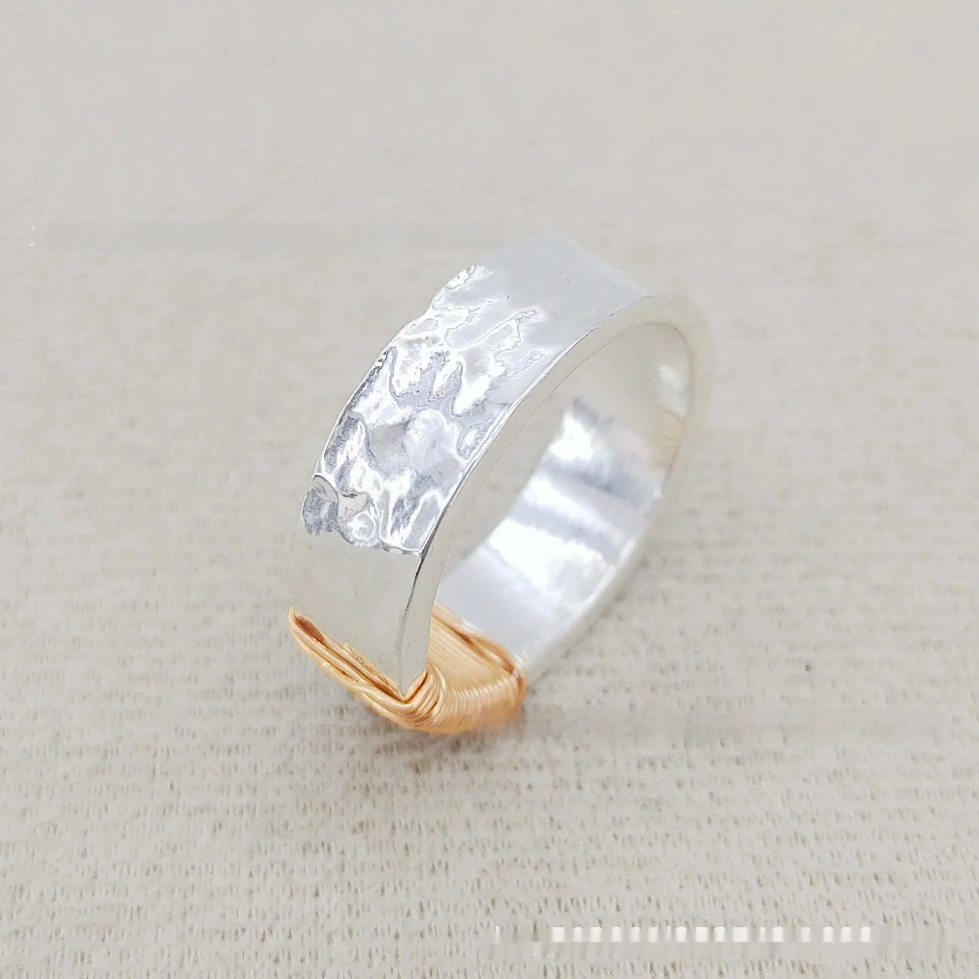 Copper wide face ring with irregular coil design in silver-gold colour.