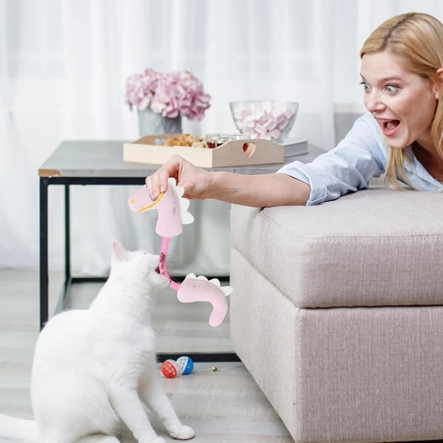 Set of four cat toys: plush fish, mouse, bunny, and a catnip rope on a pink background.