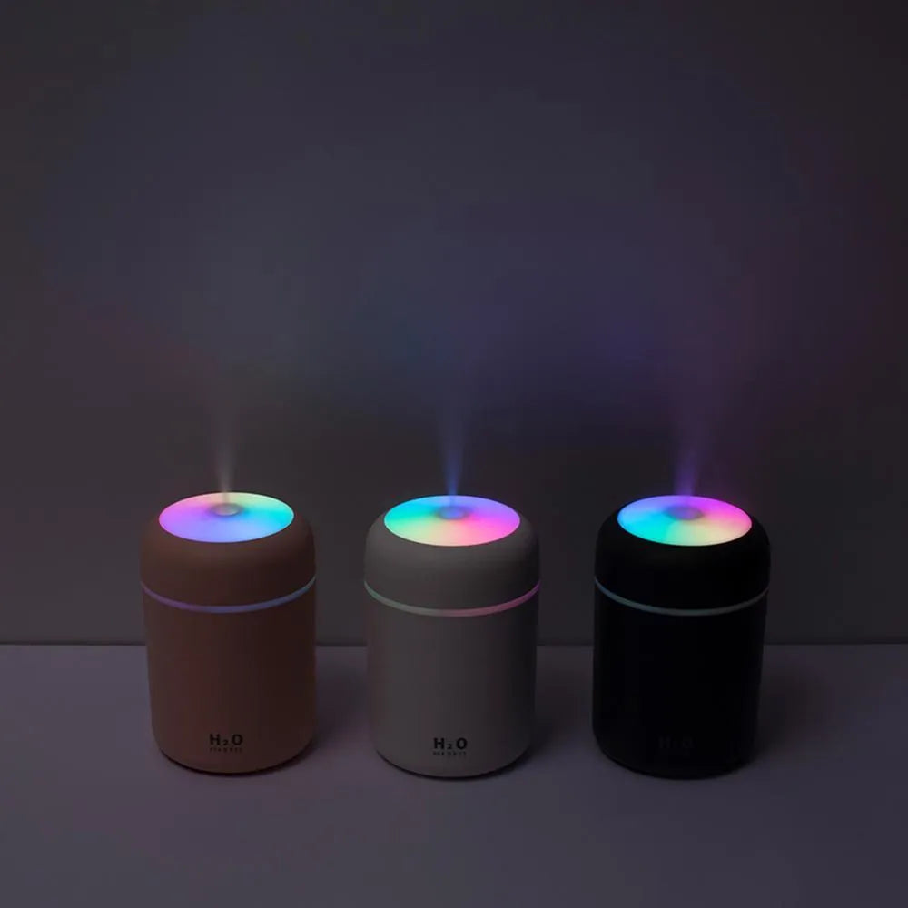 Pink USB mini humidifier with LED lights and water tank on desk